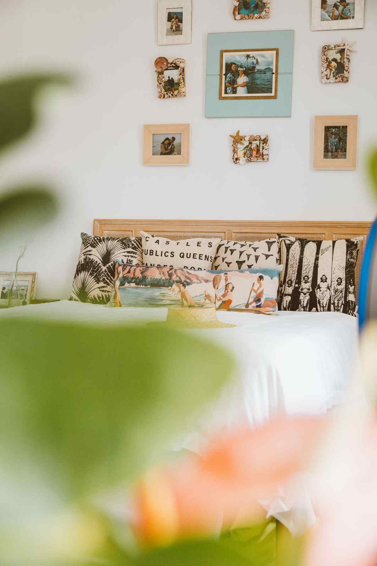 Gallery of framed family photographs hanging on a bedroom wall above a bed