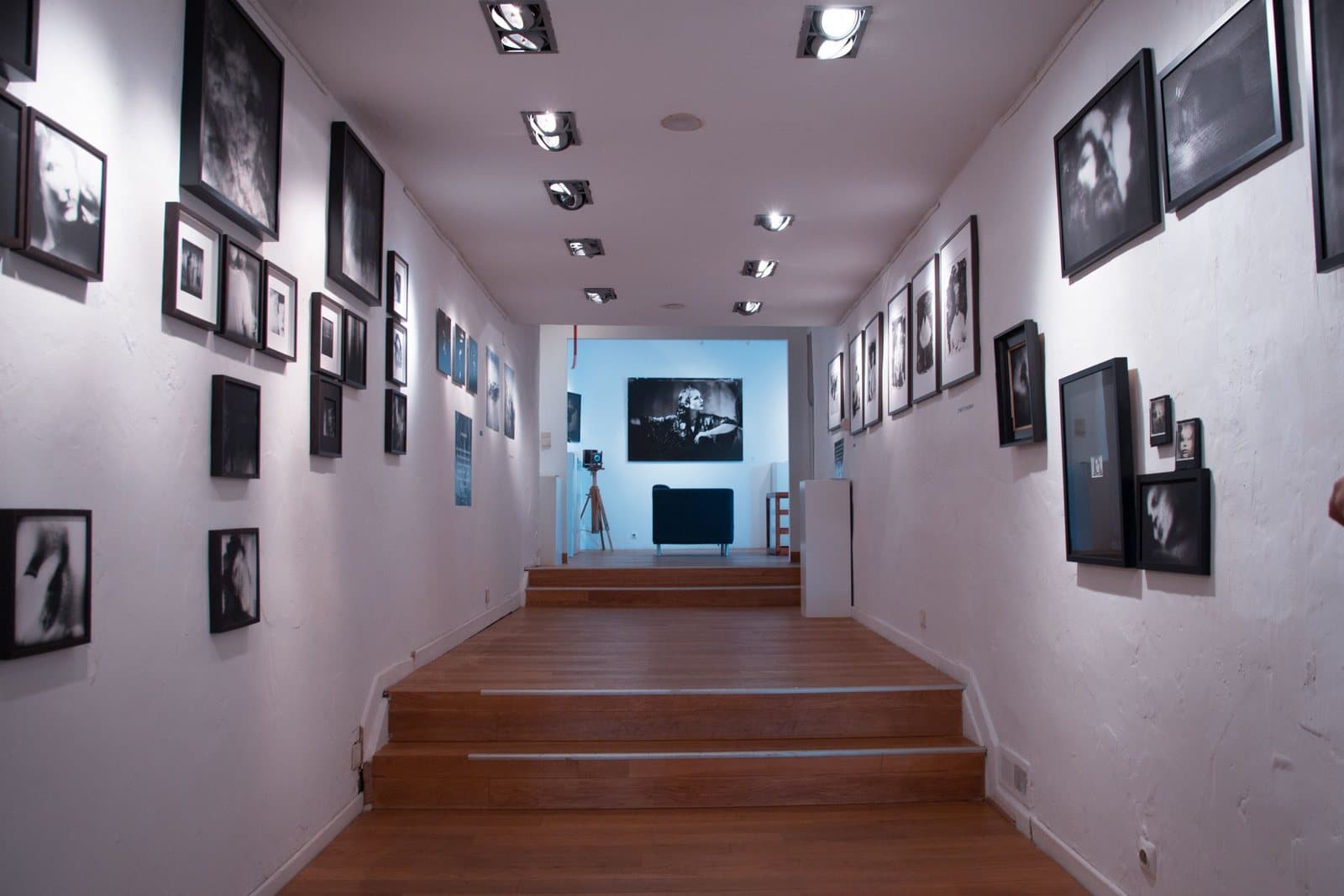 A wide hallway lined with dozens of framed photographs hung in a gallery arrangement.