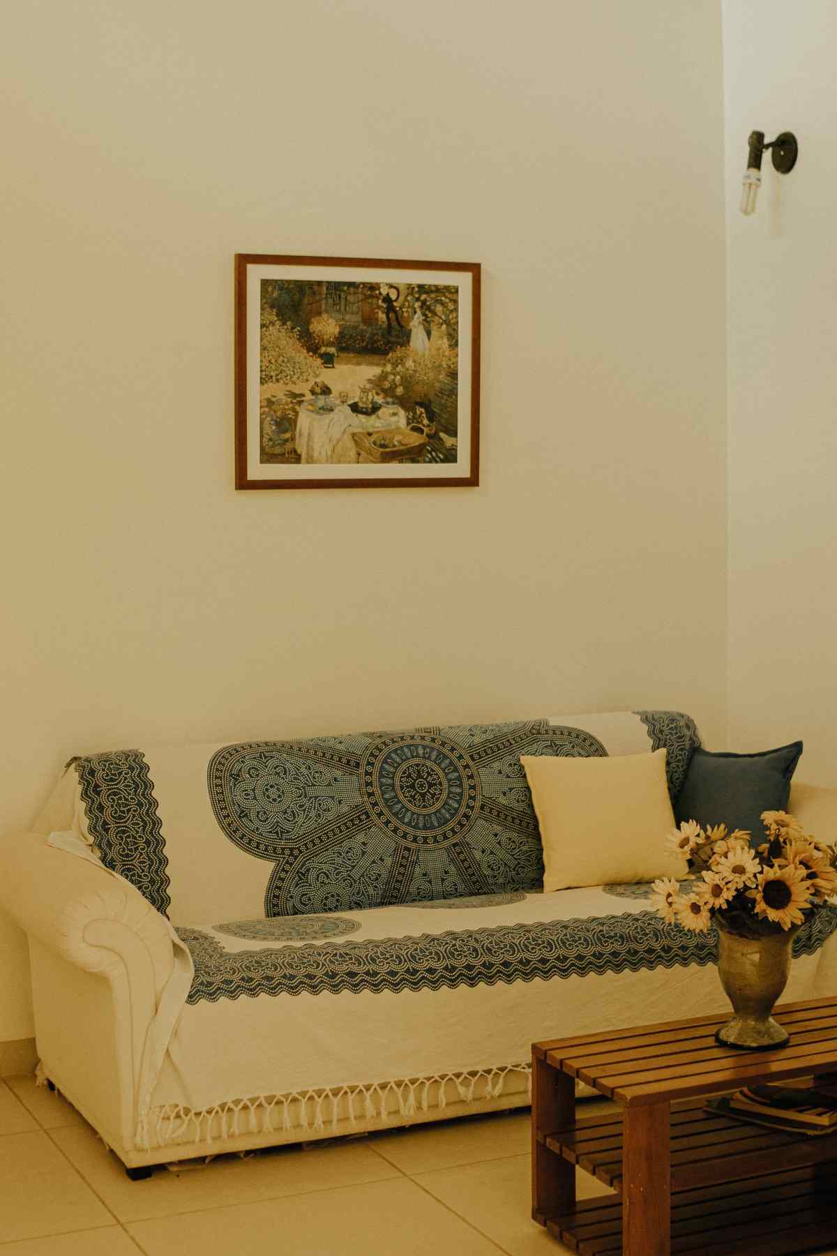 Framed painting with a white mat hanging above a patterned sofa in a living room