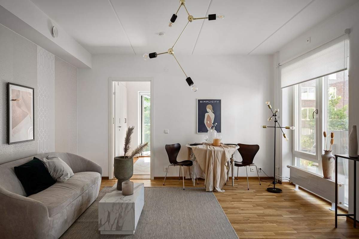 Small bright apartment living and dining area with framed artwork on the walls